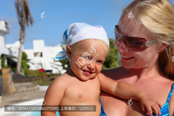 微笑的母親和女兒在游泳池旁的肖像。專注于嬰兒