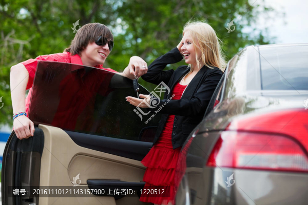 一對年輕夫婦帶著一輛新車