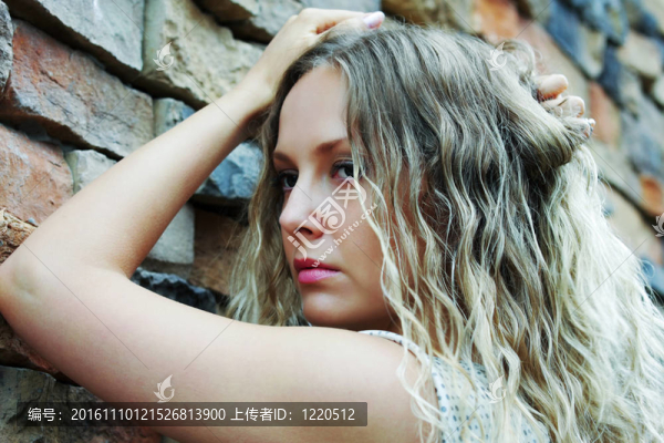 傷心的女人靠著一塊石頭墻