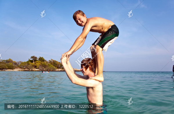 兄弟們一起在湛藍的天空中在清澈的海水中一起在海上跳躍