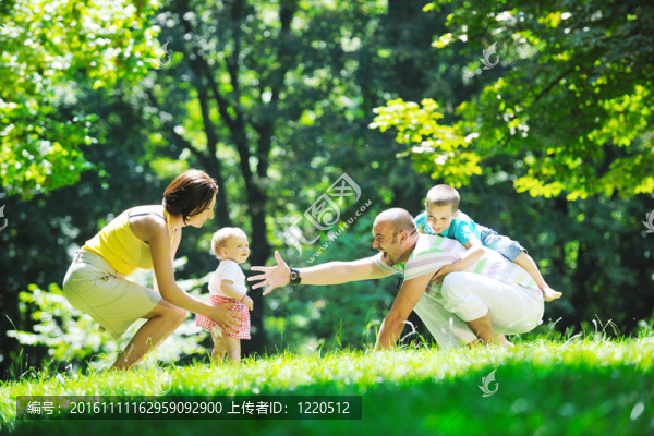 快樂的年輕夫婦和他們的孩子在公園玩得開心