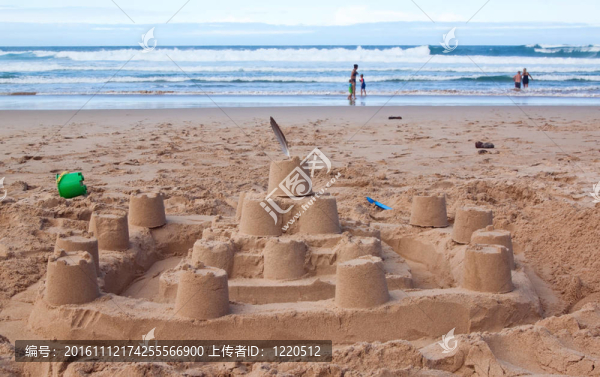 有人在沖浪，在沙灘上玩大的沙堡