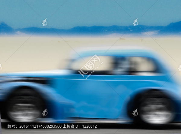 在沙漠路上快速行駛的藍(lán)色汽車(chē)