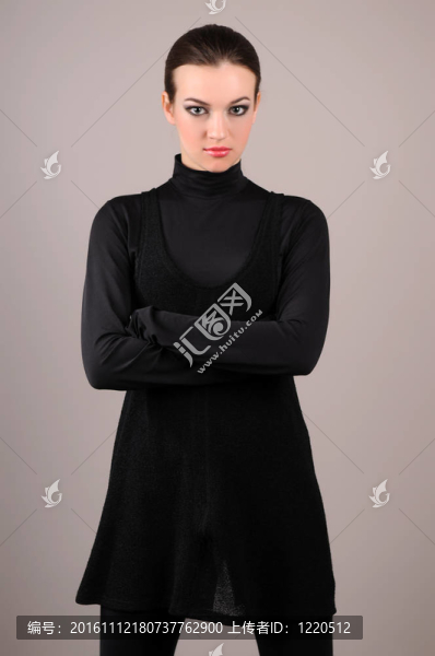 迷人的女人站在灰色背景