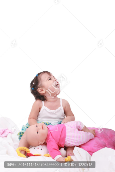 快樂的小女孩和她的洋娃娃坐在床上