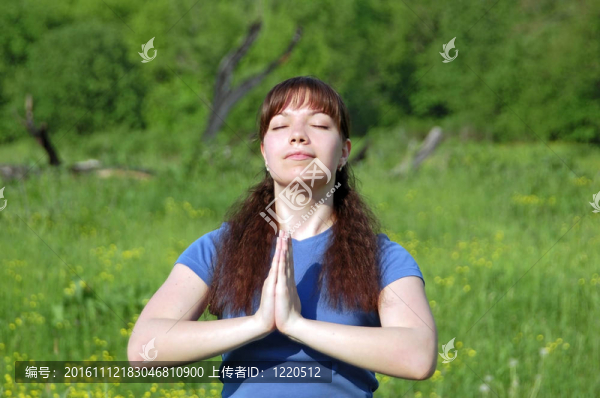 年輕快樂女子在綠色草地上練習瑜伽