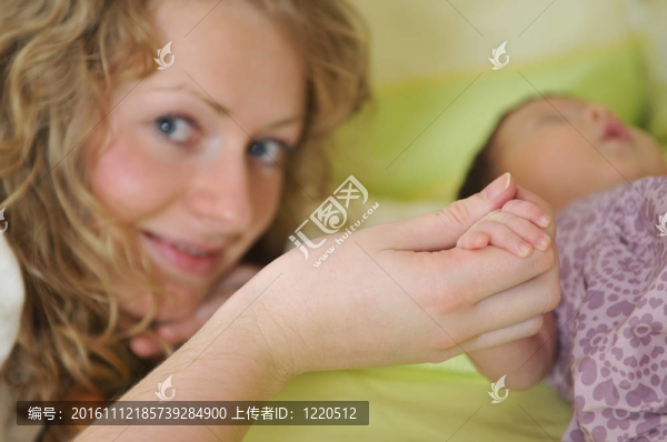 年輕漂亮母親抱著小孩子手