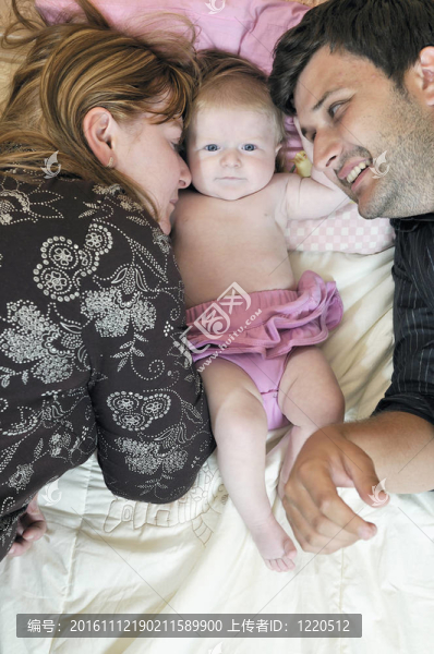 可愛的小嬰兒的年輕家庭肖像