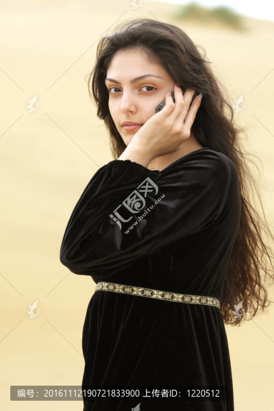 沙漠中的年輕女人用手機打電話