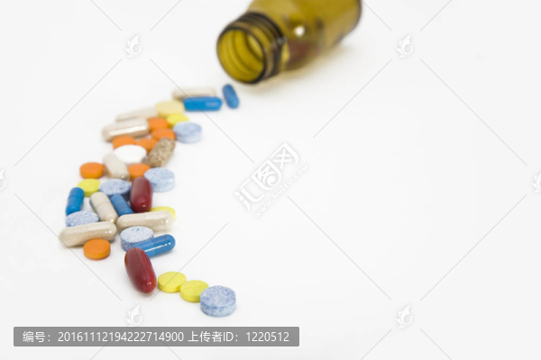 來自藥丸瓶的彩色藥丸流