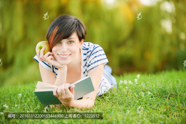 女孩躺在草地上看書