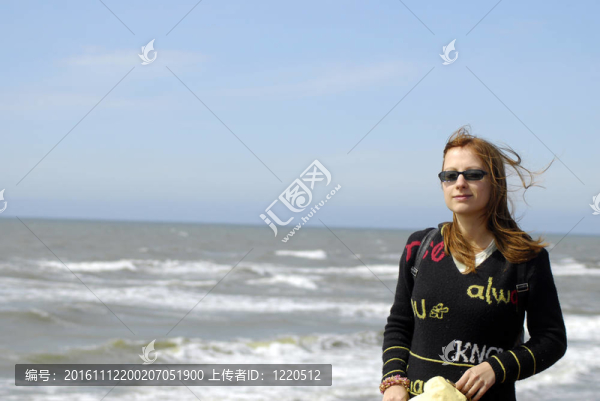 在海灘上戴著太陽眼鏡的漂亮女孩