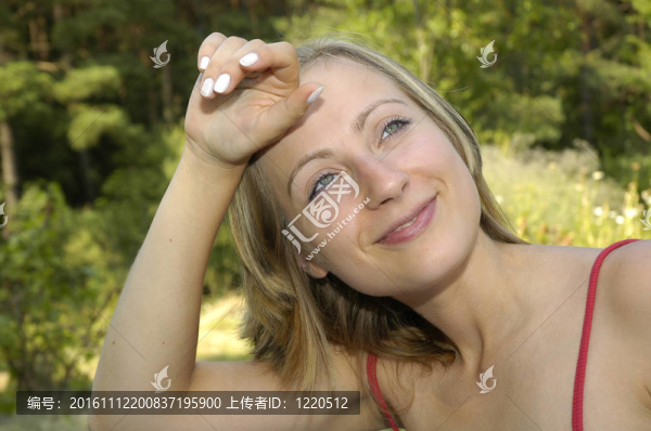 在草地上wipening額頭漂亮的女孩