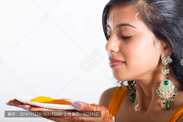 年輕的印度女人拿著香料