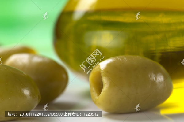 綠橄欖橄欖油在后面（非常淺的景深；重點在前面接近打開的橄欖油）