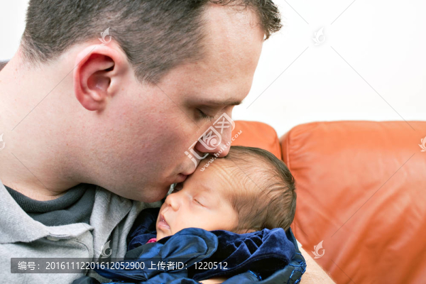 快樂的父親親吻他的新生嬰兒