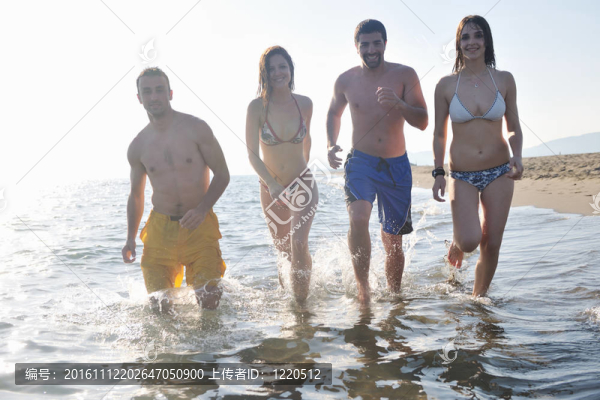快樂人團體在海灘上玩樂和跑步