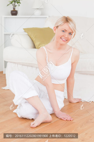 年輕的金發(fā)女子一邊坐著一邊做放松運(yùn)動(dòng)