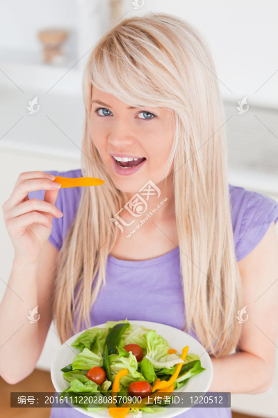 美麗的微笑女性吃沙拉