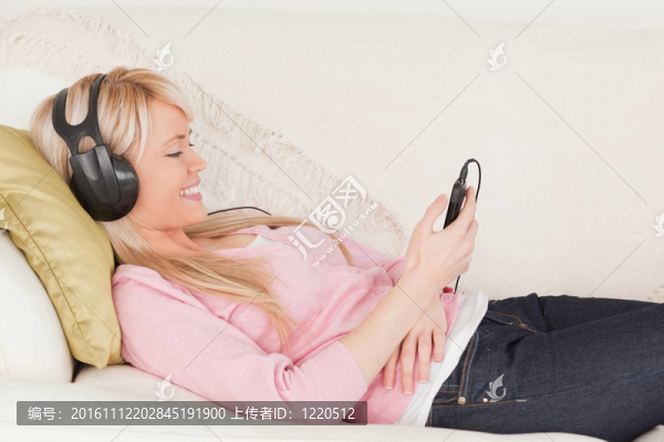 美女在躺在耳機邊聽音樂