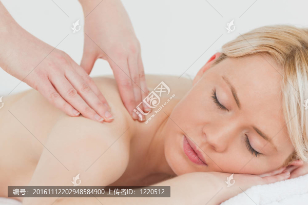 年輕漂亮的金發(fā)女人接受背部按摩的特寫