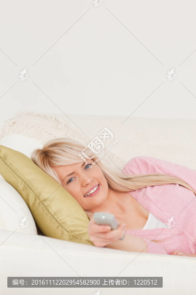 迷人的金發(fā)女子在客廳的沙發(fā)上擺姿勢(shì)