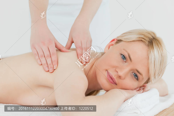 年輕漂亮的金發(fā)女性接受背部按摩的特寫