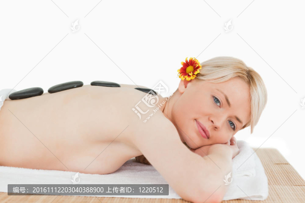 美麗的金發(fā)女人放松與熱石頭對她的背部
