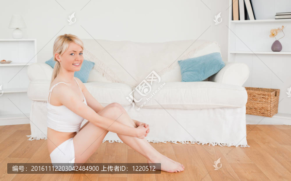 美麗的女性在穿著內(nèi)衣，而坐在地板上