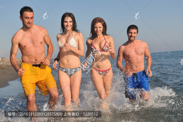 快樂人團體在海灘上玩樂和跑步