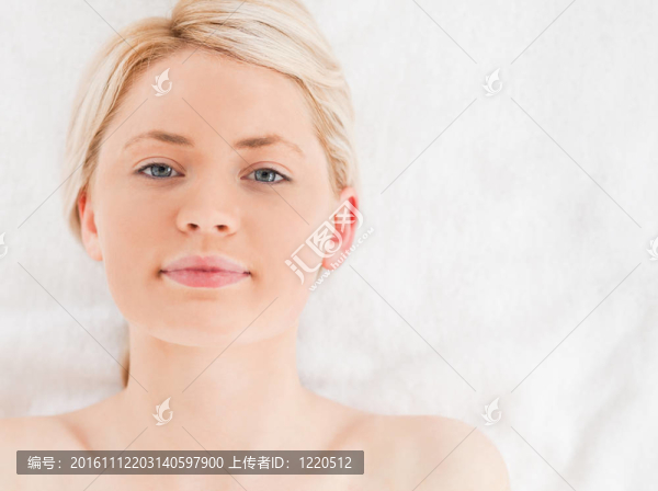 迷人的金發(fā)女人看著相機(jī)躺著