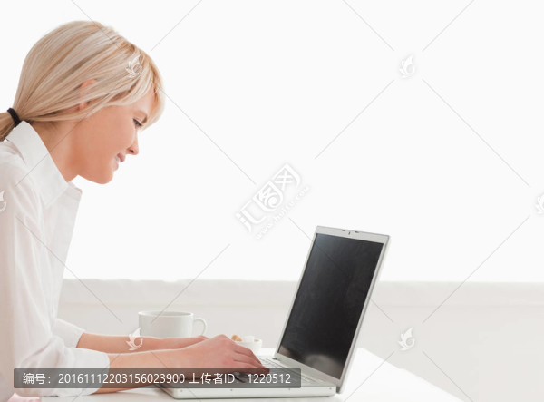 美麗的女人有她的早餐，同時放松與筆記本電腦
