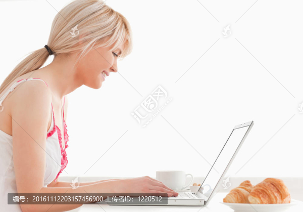 華麗的女性有她的早餐，同時放松與筆記本電腦
