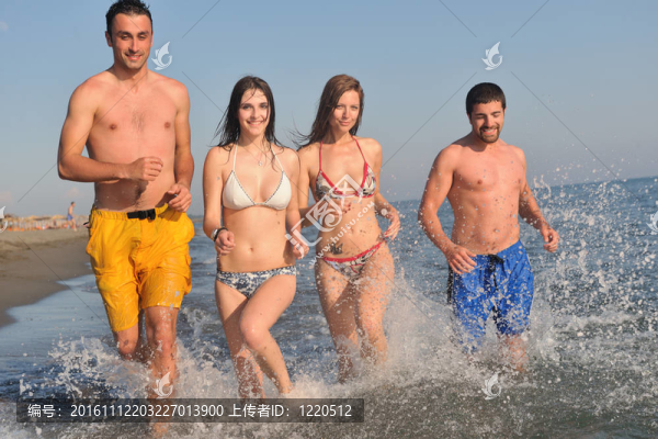 快樂人團體在海灘上玩樂和跑步