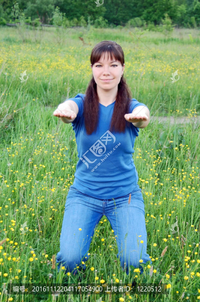 年輕女子在綠色草地上做健身操
