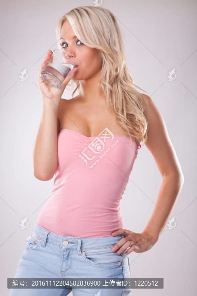 帶玻璃鮮冷水的年輕女子