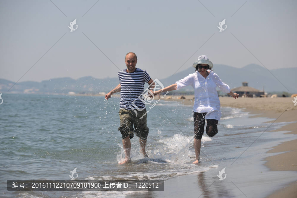 快樂的年輕夫婦在海灘上玩得很開心