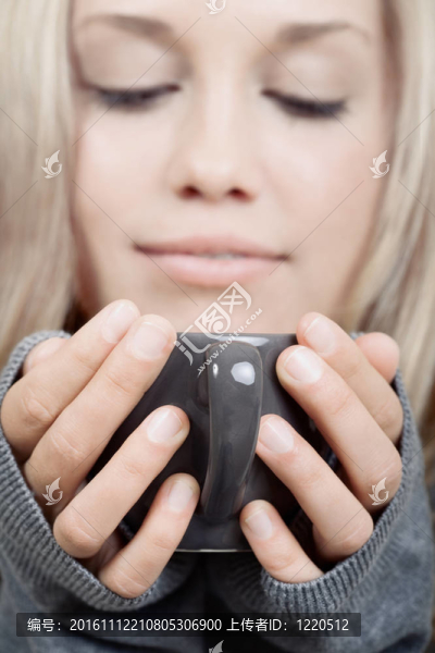 漂亮的女人拿著一杯咖啡