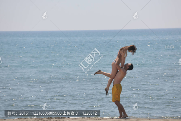 快樂的年輕夫婦在海灘上玩得很開心