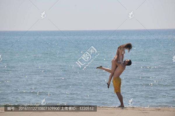 快樂的年輕夫婦在海灘上玩得很開心