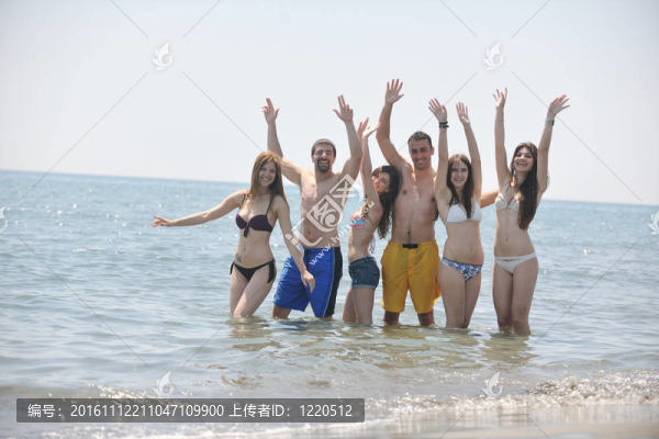 快樂(lè)人團(tuán)體在海灘上玩樂(lè)和跑步