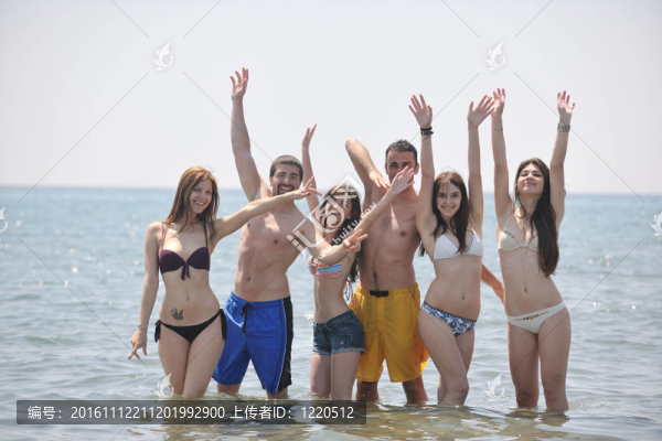 快樂人團體在海灘上玩樂和跑步