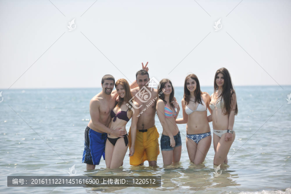 快樂(lè)人團(tuán)體在海灘上玩樂(lè)和跑步