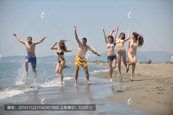 快樂人團(tuán)體在海灘上玩樂和跑步