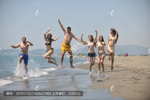 快樂人團(tuán)體在海灘上玩樂和跑步