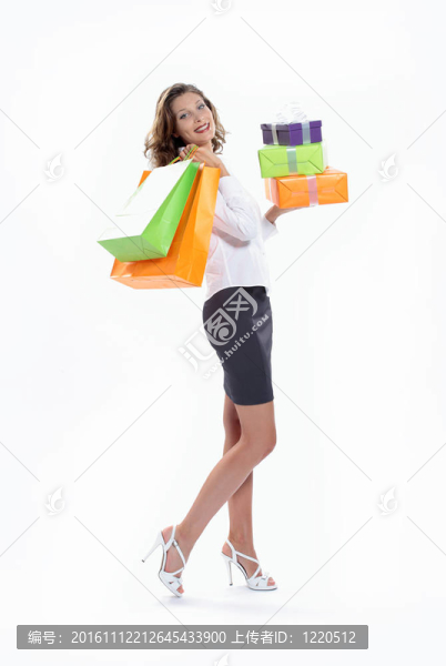 微笑的女人拿著購物袋和禮品盒對著白色的背景