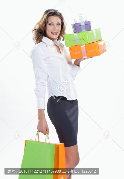 微笑的女人拿著購物袋和禮品盒對(duì)著白色的背景
