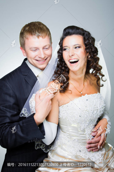 工作室的年輕優(yōu)雅的笑，剛剛結(jié)婚新郎新娘和擁抱灰色背景
