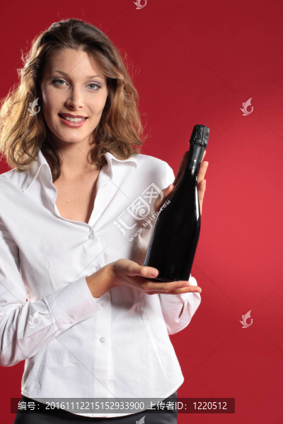 年輕迷人的女人帶著一瓶汽酒