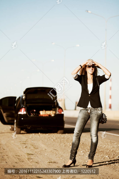 年輕的女人有一輛壞了的汽車
